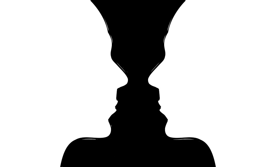 An optical illusion image depicting a black vase or two face profiles facing each other on a white background. The image plays with positive and negative space, allowing the viewer to see either a vase or two silhouettes.